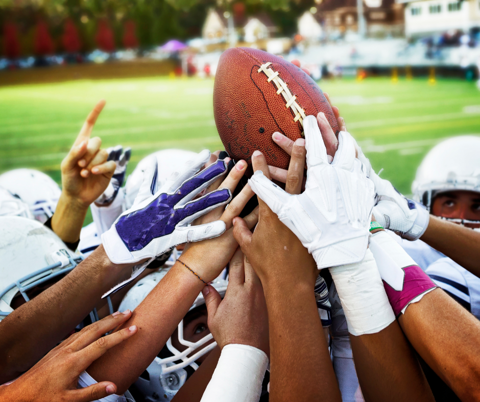 football players' hands holding ball