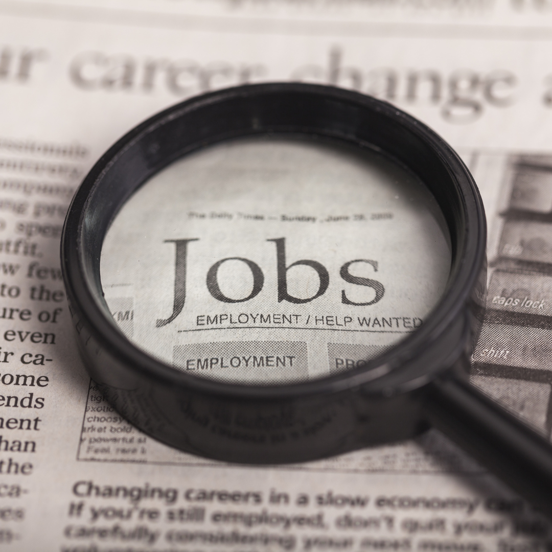 newspaper that reads "jobs" with a magnifying class on top of it