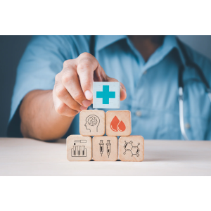 person stacking blocks that have medical icons on them