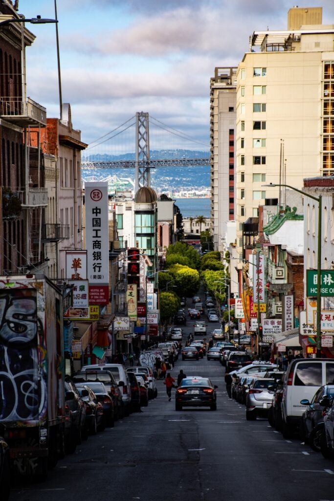 downtown area of a city looking downhill with a body of water and bridge in the background