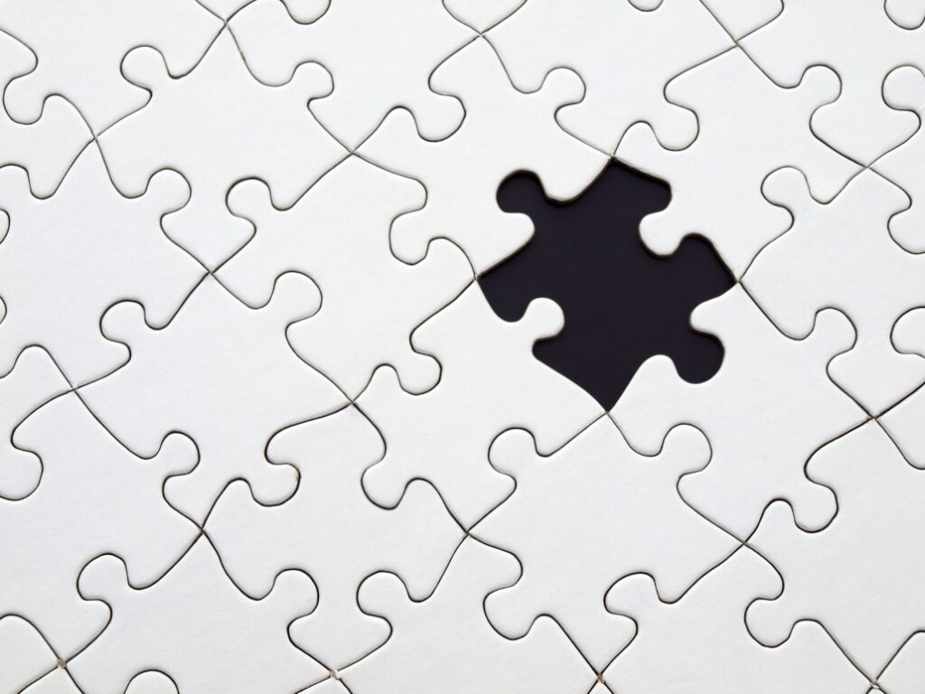 white puzzle pieces with one black puzzle piece