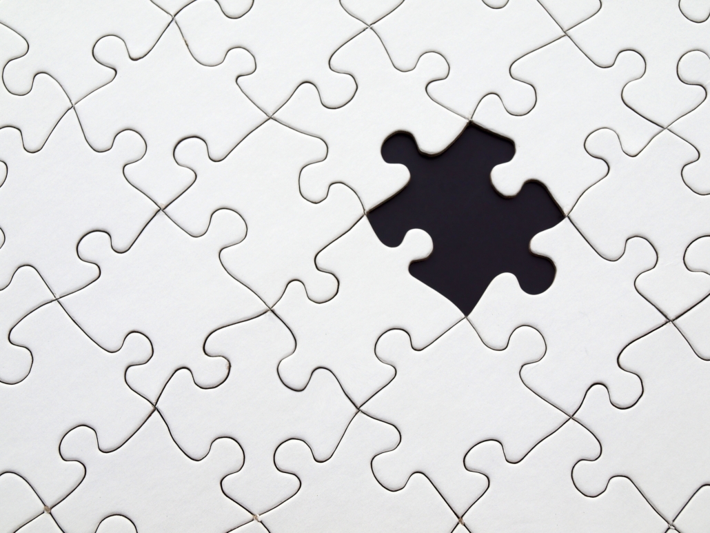 white puzzle pieces with one black puzzle piece
