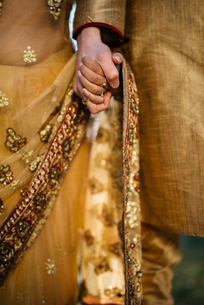 zoomed in image of two people holding hands and wearing traditional clothing