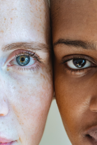 two people with the sides of their heads touching and zoomed in to see one eye from each person