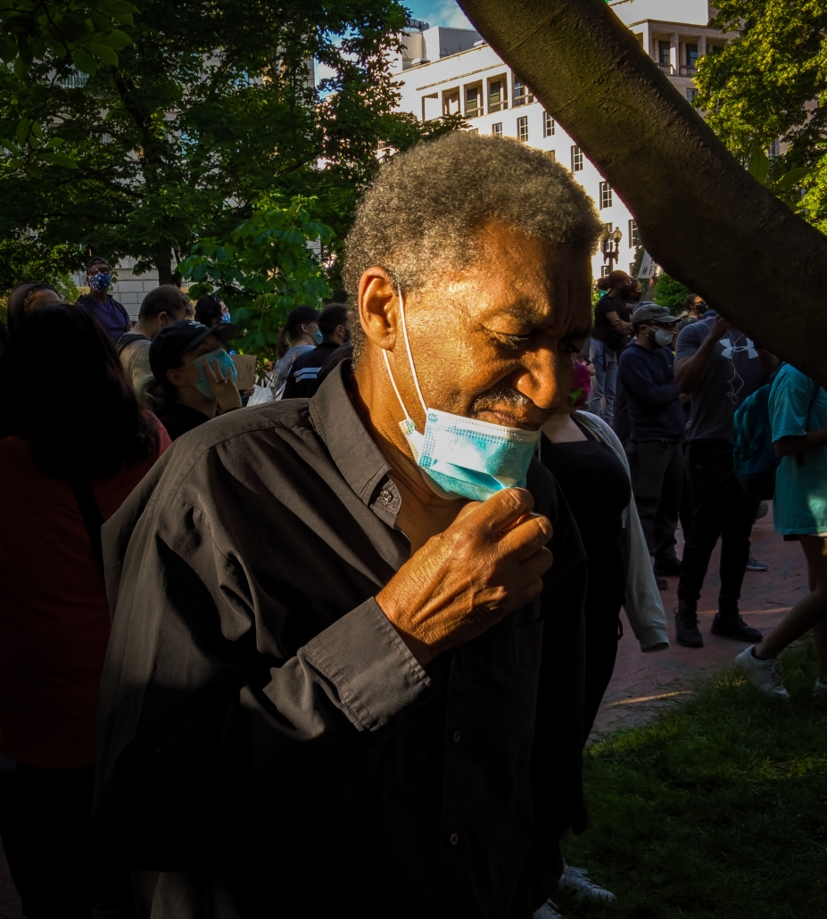 man smiling and pulling down his mask