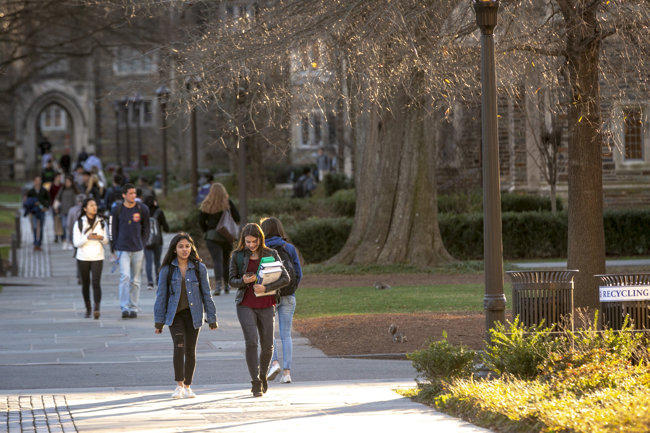 students walking on a path with Duke's campus in the background