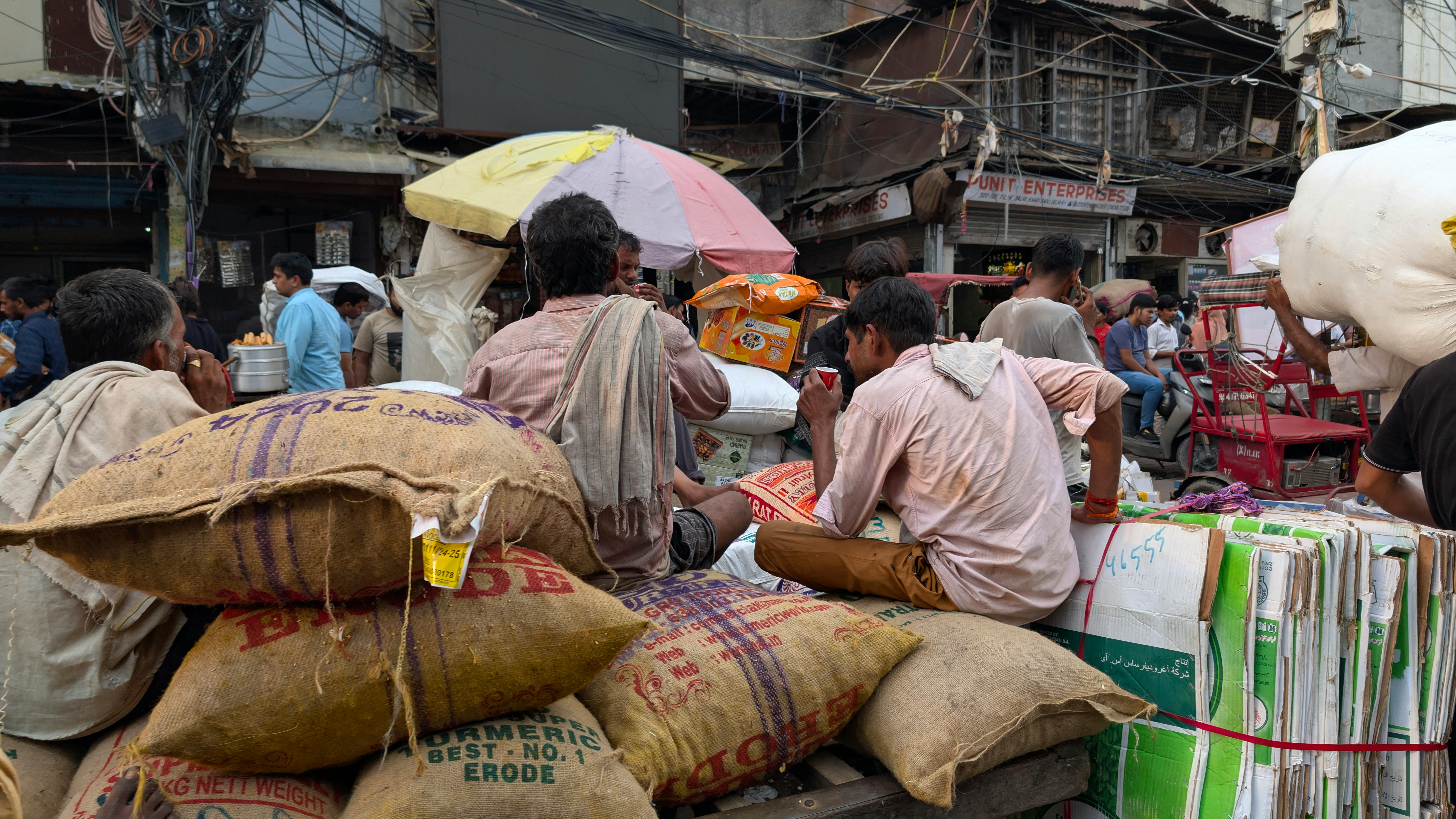 Laborers Rest Amidst Bustling Delhi Street Life